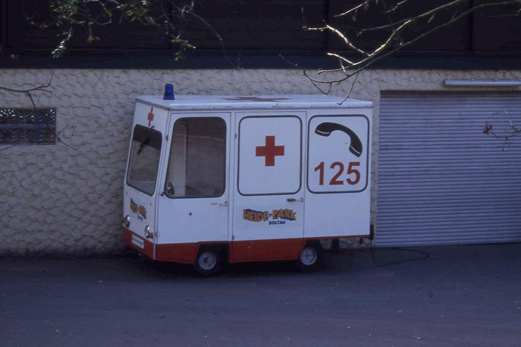 Am 20.9.1998 stand dieser kuriose  Krankenwagen  mit Blaulicht
als Rettungsfahrzeug im Heidepark Soltau. - Ob es dieses Gefhrt
heute noch gibt, wei ich nicht. Offensichtlich hat das Gefhrt 
einen Elektroantrieb.