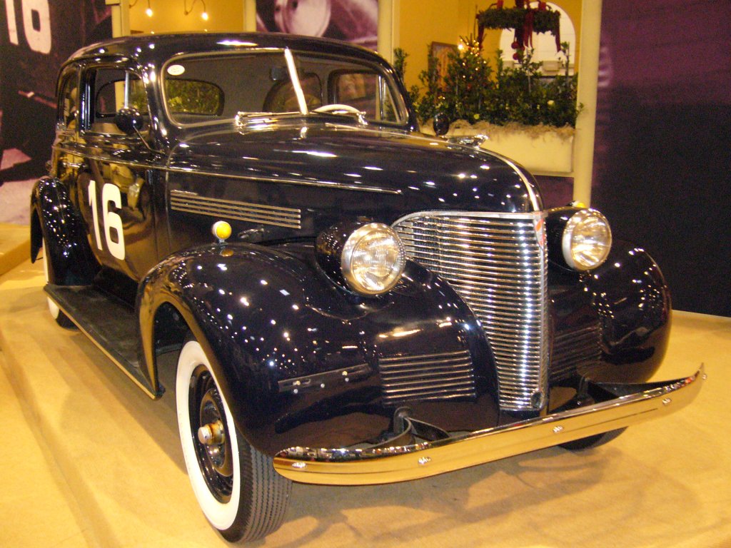 Chevrolet Master de Luxe Town Sedan des Jahrganges 1938. Beim Modell Town Sedan handelt es sich um ein 2-triges, fnfsitziges Fahrzeug. Ein solcher  Town Sedan  war 1938 ab US$ 750,00 zu haben. Diese Karosserievariante verkaufte sich im Modelljahr 1938 insgesamt 186.233 mal. Der 6-Zylinderreihenmotor leistet 85 PS aus 3.540 cm Hubraum. Aus einem Coupe dieser Baureihe, baute sich der legendre Juan Manuel Fangio, seinen ersten Langstreckenrennwagen und gewann damit seine ersten Rennen. Essen Motor Show am 29.11.2011.