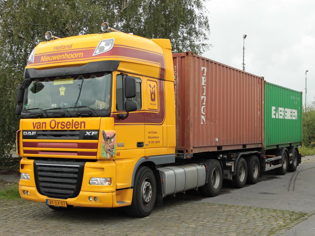 DAF XF mit Combitrailer am 26.07.2011 am Aachener Westbahnhof. Der Combitrailer ist besonders in den Niederlanden verbreitet und hat den Vorteil, das man zwei 20 Fu Container mit einen Auflieger fahren und an einer Rampe ausladen kann. Man kann den Combitrailer trennen. Der erste Teil ist ein Sattelanhnger (roter Container) an dem ein zweites Fahrzeug (grner Container) fest angehngt werden kann. Dazu werden die vorderen Achsen des Trailers abgesenkt und vom hinteren Teil getrennt. Mit dem roten Container fhrt der Fahrer an die Rampe, ld aus, hngt den grnen Container wieder an und fhrt damit an die Rampe. In Deutschland braucht man fr den Combitrailer eine Ausnahmegenehmigung weil es sich Verkehrsrechtlich um zwei Anhnger handelt.