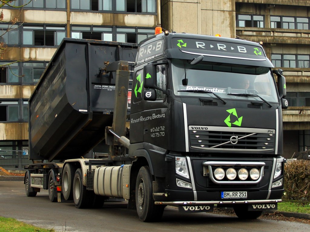 Ein schner schwarzer Volvo FH der Firma Rohstoff Recycling Bedburg (RRB) zieht sich am 24.01.2012 einen Abrollcontainer von seinem Hnger auf die Zugmaschine.