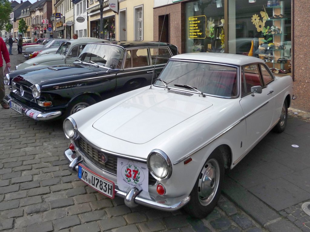 Eine Reihe von Old- und Youngtimern prsentiert sich bei der Oldtimer-Rallye in Hls, ganz vorne im Bild ein Fiat 1500 Coupe.