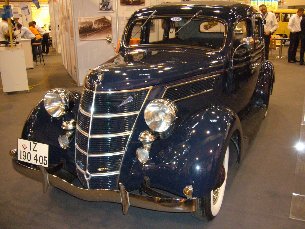 Ford V8 Limousine mit 4-triger Ambi-Budd Karosserie. 1937 - 1938. Der V8 war Ende der 1930´er Jahre das Spitzenmodell aus Kln-Niehl. Motorisiert mit einem V8-motor mit 3.620 cm Zylinderinhalt leistete der Wagen 90 PS. Aufgrund seiner Robustheit wurden fast alle V8 Fordmodelle zum Kriegsdienst eingezogen. Wenn man dem Kennzeichen glauben schenken darf, hat dieser Wagen in der Rheinprovinz (Kennzeichen IZ) berlebt. Der rote Winkel auf dem Nummernschild besagt, das das Auto auch whrend der Kriegszeit privat genutzt werden durfte. Als weitere Karosserievarianten gabe es noch eine Speziallimousine mit einer Art Flieheck (Karosserie ebenfalls von Ambi-Budd) und ein von Deutsch karossiertes Cabriolet. Techno Classica 03.04.2011.