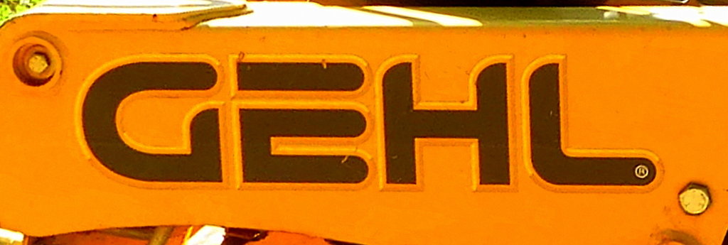 Gehl, Schriftzug am Kompaktlader der US-amerikanischen Firma Gehl Company, baut Lader und Baufahrzeuge, gehrt seit 2008 zu Manitou S.A., Okt.2017
