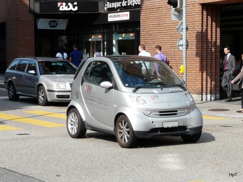 Grauer Werbe Smart unterwegs in der Stadt Lugano am 30.09.2011