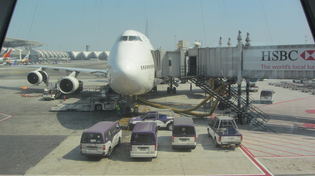 Grenvergleich zwischen einem  Jumbo  (Boeing 747-400) und einigen Flughafenfahrzeugen der Thai am 6.1.2012 am Suvarnabhumi Airport in Bangkok.