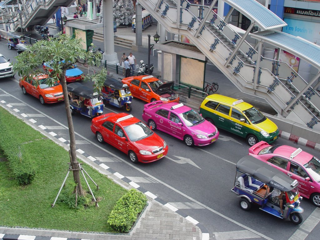 Halt bei einer Ampelanlage in Bangkok am 13.01.2011. Zu sehen sind auf dem Foto insgesamt 12 Taxen: 5 Tuk-Tuk und 7 Taxi Meter, wobei jede Taxigesellschaft eine eigene Farbe oder Farbkombination hat.