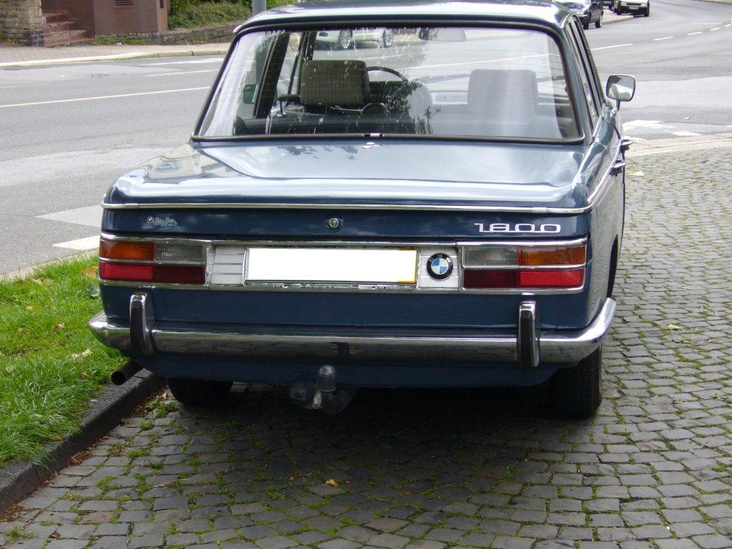 Heckansicht eines BMW 1800. 1963 -1971. Die so genannte  Neue Klasse  wurde bereits auf der IAA 1961 vorgestellt und kam ab 1962 mit dem Modell 1500 zu den Hndlern. 1963 folgte der 1800´er. 1964 kam der 1600´er und 1966 gar der 2000´er. Die Modelle ab 1800 cm Hubraum waren an der durchgehenden  Chromleiste zu erkennen. Der 4-Zylinderreihenmotor des abgelichteten BMW leistet aus 1.773 cm 90 PS. Der Motor gnnte sich 12 Liter Super auf 100 km. Essen 24.06.2011.