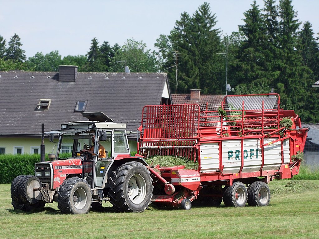 MF392 holt mit dem Pttinger-PROFI-Ladewagen das geschnittene Gras von der Wiese;100625