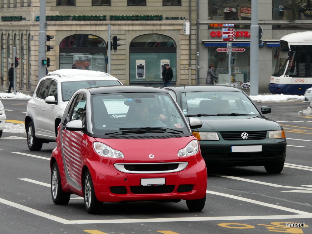 Rot und Silbergrauer Smart unterweg in der Stadt Genf am 14.02.2013