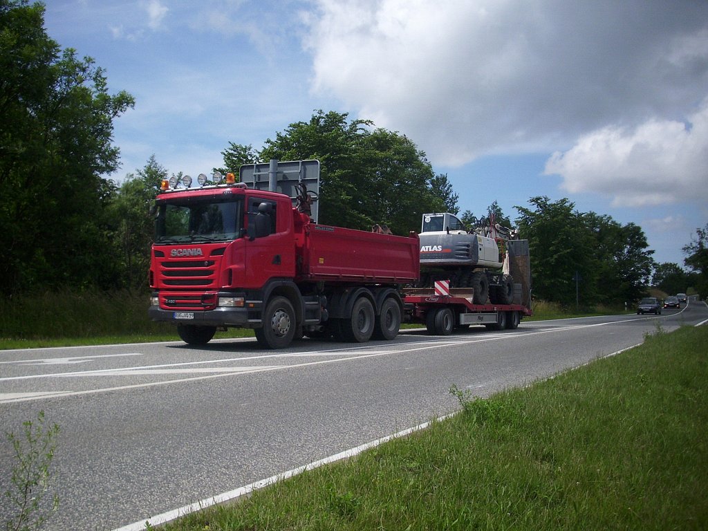 Scania Kipper mit Schwerlasthnger und mit einem Atlas Bagger in  Sassnitz am 02.07.2012