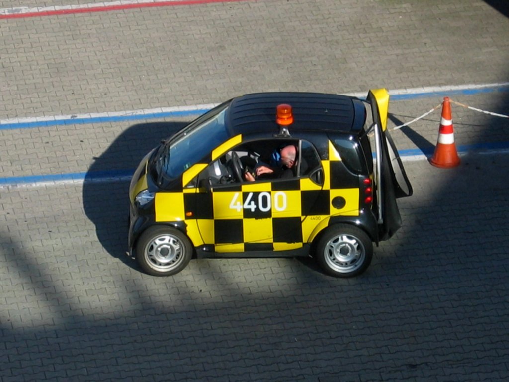 Smart fortwo in der Lackierung eines Vorfeldkontrollfahrzeuges. Hiermit fahren die Bediener der Fluggastbrcken
 zu ihrem Einsatzort. Aufgenommen am 17.10.2006 auf dem Flughafen Kln/Bonn.

