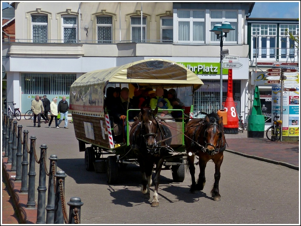 Voll mit Fahrgsten ist diese Pferdegespann mit Planwagen auf der Insel Borkum unterwegs. 12.05.2012
