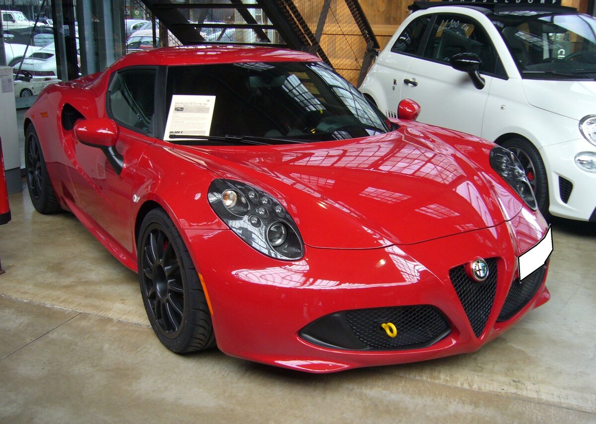 Alfa Romeo 4C Coupe. Der Sportwagen wurde 2011 vorgestellt und konnte von 2013 bis 2020 als Coupe oder Cabriolet bestellt werden. Die Herstellung des Fahrzeuges erfolgt bei der Konzernschwester Maserati. Der Vierzylinderreihenmotor mit 16- Ventiltechnik und Abgasturbolader hat einen Hubraum von 1742 cm³ und leistet 240 PS. Die Höchstgeschwindigkeit gab man in Milano mit 258 km/h an. Das gezeigte 4C Coupe im Farbton rosso alfa wurde im Jahr 2017 produziert. Classic Remise Düsseldorf am 30.10.2023.