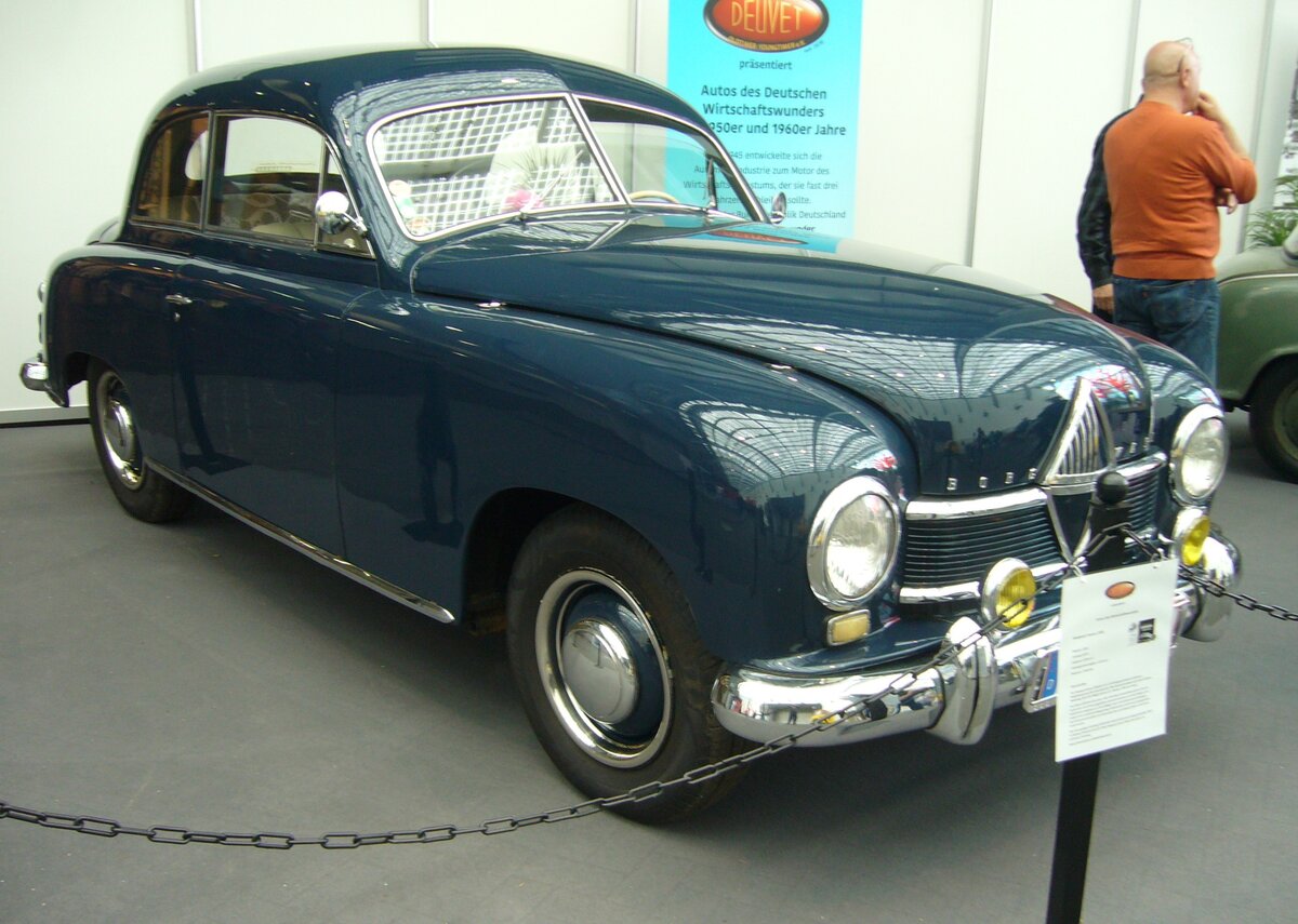 Borgward Hansa 1500 in der Karosserieversion zweitürige Limousine. Für gewaltiges Aufsehen sorgte der Hansa 1500 bei seiner Vorstellung auf dem Genfer Salon im März 1949. Er war der erste völlig neue PKW der deutschen Autoindustrie nach WW2 und zugleich das erste deutsche Auto mit einer Pontonkarosserie nach US-amerikanischen Vorbild. Das Modell war als zwei- und viertürige Limousine, als zweitüriges, viersitziges Cabriolet und zweitüriges Kombimodell lieferbar. Bis zur Ablösung durch den ähnlichen Hansa 1800 im Sommer 1952 wurden insgesamt 23.140 Hansa 1500 (alle Karosserieversionen zusammen gerechnet) gebaut. Eine solche zweitürige Limousine schlug im Jahr 1949 mit einem Kaufpreis von DM 7.600,00 zu Buche. Dafür bekam man ein solides und robustes Auto mit hervorragenden Fahreigenschaften. Der Vierzylinderreihenmotor hat einen Hubraum von 1498 cm³ und leistete anfänglich 48 PS. Im Herbst 1950 stieg die Motorleistung auf 52 PS. Die Höchstgeschwindigkeit gaben die Bremer mit 121 km/h bei einem Verbrauch von 10 Litern auf 100 Kilometer an. Techno Classica Essen am 05.04.2024.