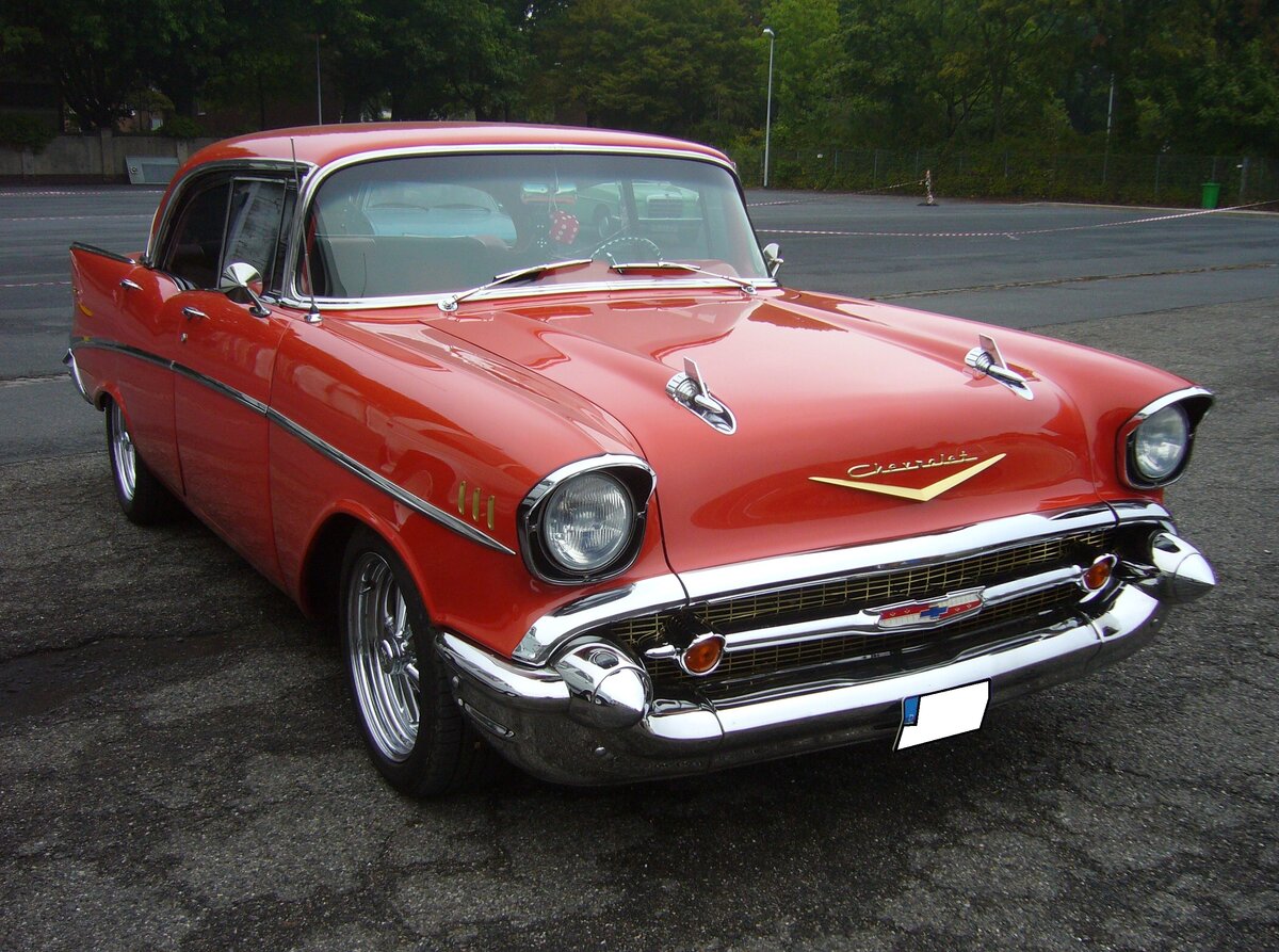 Chevrolet Series 2100B Hardtop Sport Sedan aus dem Jahr 1957. Die so genannte Series two-ten war die mittlere Ausstattungsvariante des Chevrolet-Kultmodelljahres 1957. Eine solche, viertürige und sechssitzige Limousine war ab US$ 2270,00 zu haben und verkaufte sich in dieser Modellreihe und Karosserieversion in diesem Jahr 16.178 mal. Das Modell war mit etlichen Sechszylinderreihenmotoren und V8-Motoren lieferbar. Aus dem vergoldeten V auf der Motorhaube lässt sich schließen das der gezeigte  Chevy  mit einem V8-Motor ausgerüstet ist. Oldtimertreffen an Mo´s Bikertreff in Krefeld am 11.09.2022. 
