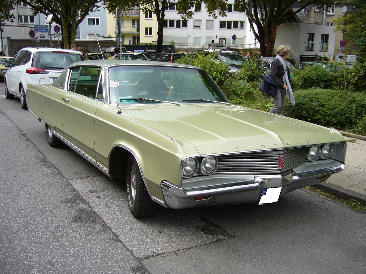 Chrysler Newport Custom des Jahrganges 1968. Von diesem Coupemodell wurden in diesem Modelljahr 38.317 Einheiten gefertigt. Bei der Motorisierung konnte man zwischen einem 6.3 und einem 7.2 Liter V8-motor wählen. Der Farbton müßte sich Amber Sherwood metallic nennen. Duke of Downtown am 09.09.2017 in Essen-Rüttenscheid.