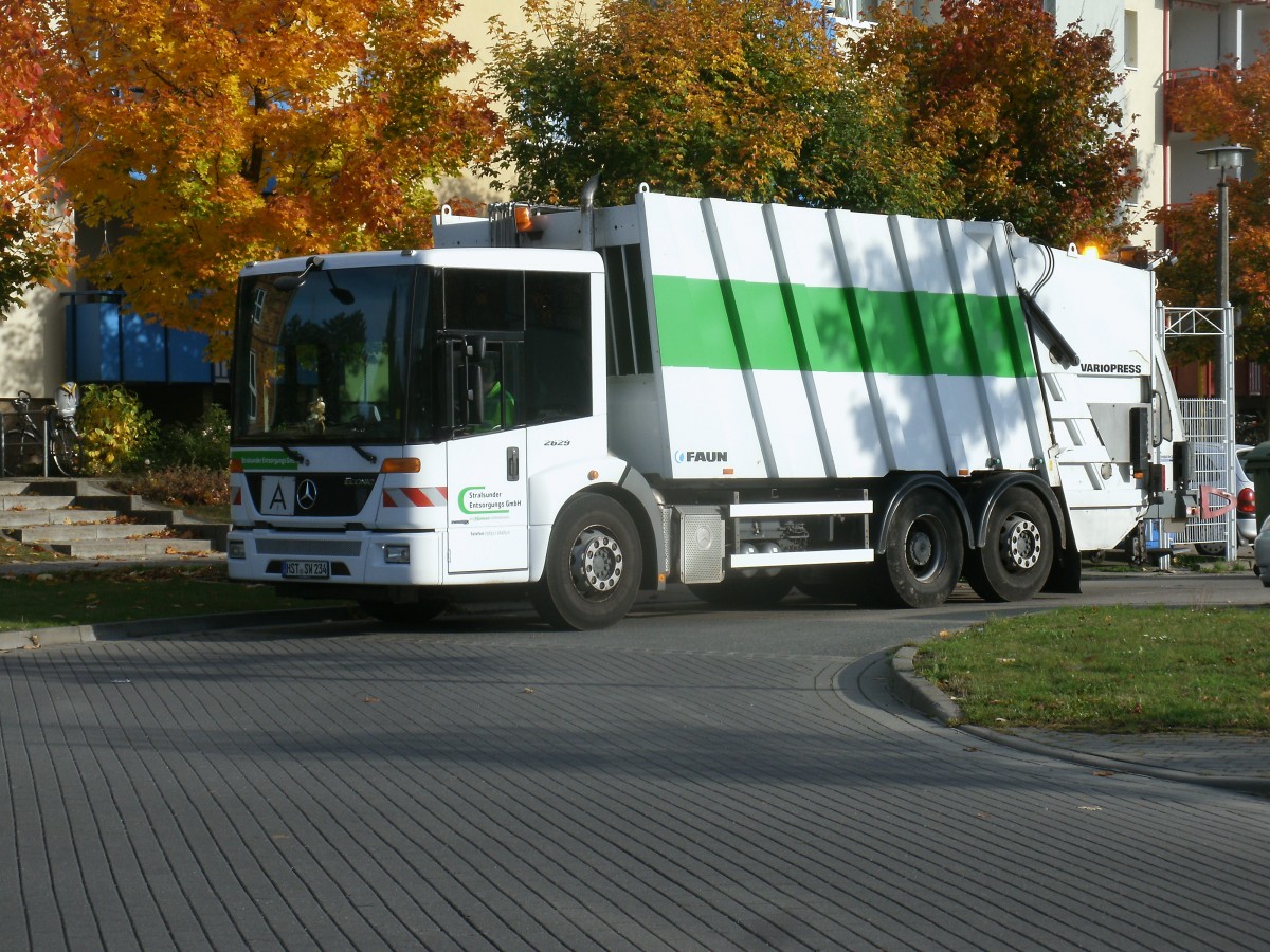 Die Stralsunder Mllabfuhr mit ihrem Mercedes,am 14.Oktober 2013 unterwegs im Stralsunder Stadtteil Grnhufe.