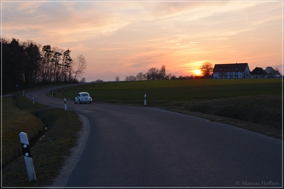 Ein VW Käfer 1300 fährt dem Sonnenuntergang entgegen. Aufgenommen am 16. März 2015