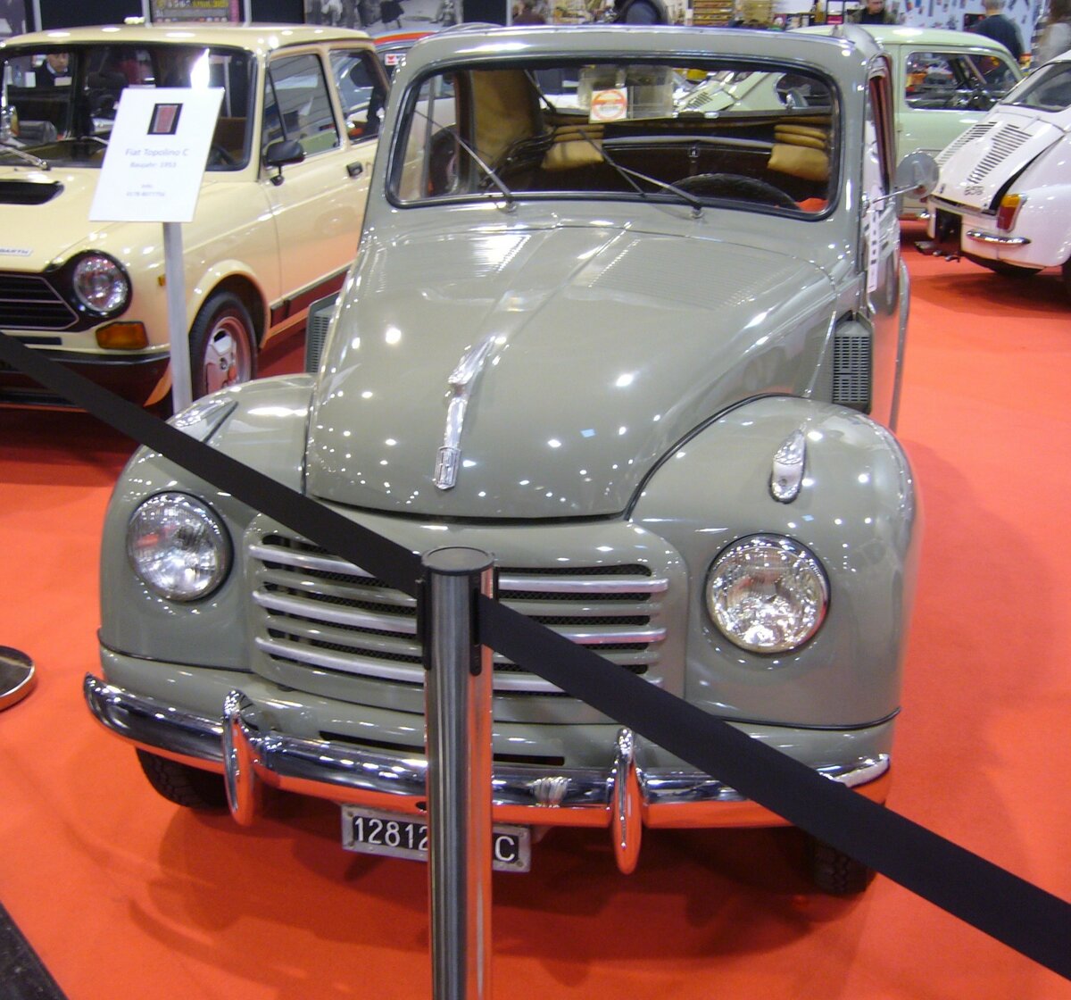 Fiat 500C  Topolino , gebaut in den Jahren von 1949 bis 1955. Vorgestellt wurde der 500´er bereits im Jahr 1936. Er war eine geniale Konstruktion des legendären Ingenieurs Dante Giacosa (*1905 +1996). Nach WW2 wurde die Produktion wieder aufgenommen. Ab dem Modelljahr 1949 erhielt der Kleinwagen eine modernisierte Front. Der Vierzylinderreihenmotor leistet 16,5 PS aus einem Hubraum von 570 cm³. Wie an den noch montierten, alten, italienischen KFZ-Kennzeichen ersichtlich ist, war dieser  Topolino  in der Provinz Macerata/Marken zugelassen. Essen Motorshow am 06.12.2023.