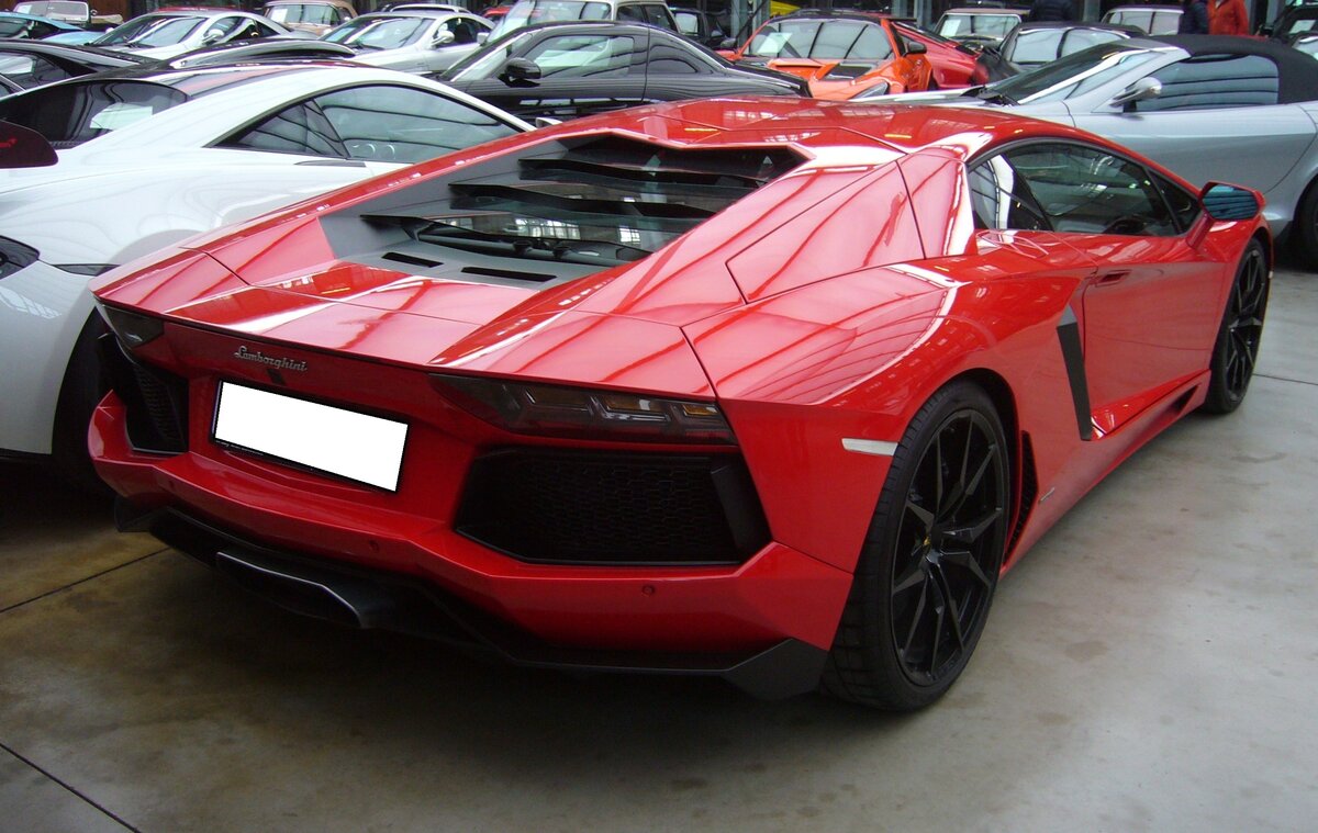 Heckansicht eines Lamborghini Aventador LP 700-4 Coupe im Farbton rosso mars. Classic Remise Düsseldorf am 26.02.2024.