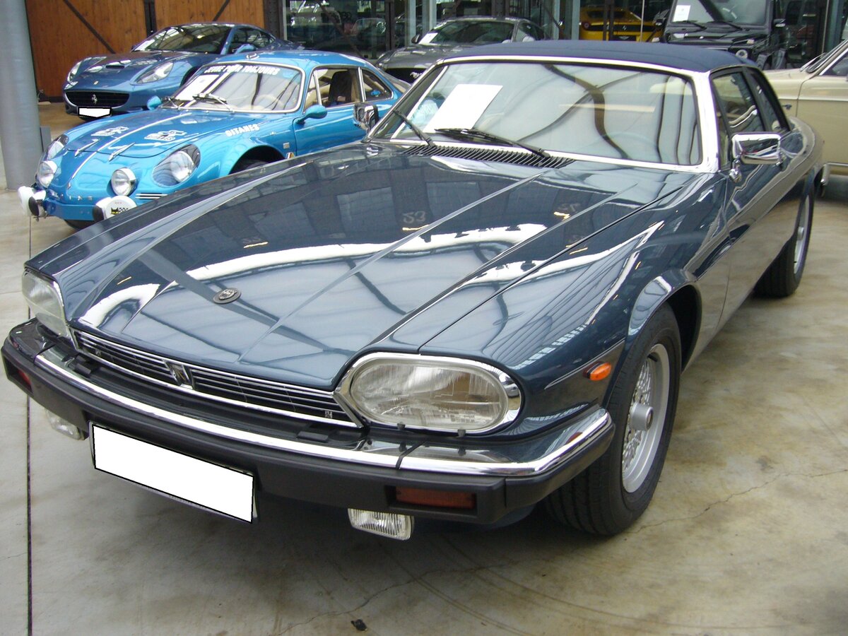 Jaguar XJS MK2 V12 Convertible aus dem Jahr 1989. Die Sportwagen Baureihe XJS wurde bereits im Jahr 1975 vorgestellt und in drei Baureihen (MK1 bis 1981, MK2 bis 1991 und MK3 bis Ende 1996) als Coupe und Cabriolet (Convertible) gebaut. Hier konnte ich ein MK2 Convertible im Farbton royalblue ablichten. Der V12 war das Spitzenmodell der XJS MK2-Baureihe. Wie aus der Typenbezeichnung schon ersichtlich, wird dieses klassische, britische, Auto von einem V12-Motor angetrieben. Dieser  Zwölfender  hat einen Hubraum von 5341 cm³ und leistet 264 PS. Classic Remise Düsseldorf am 26.02.2024.