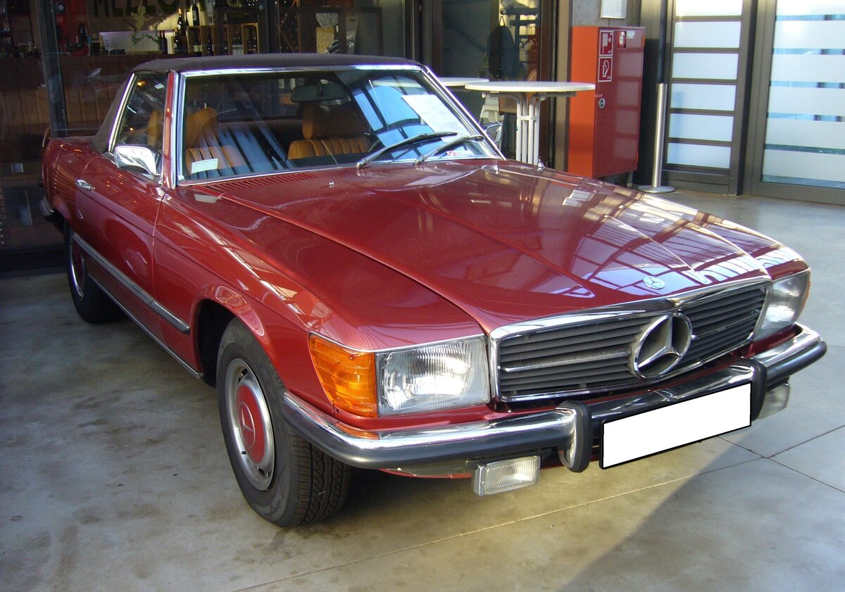 Mercedes Benz R107 450SL. Als 350SL kam der Nachfolger der  Pagoden-Mercedes W113  im April 1971 auf den Markt. Die Motorenpalette wurde ständig erweitert, so das im März 1973 das neue  Spitzenmodell  450SL auf den Markt kam. Somit gehört der gezeigte 450SL im Farbton rotmetallic DB571 mit seiner Erstzulassung im Juli 1973, zu den ganz frühen Modellen dieser Baureihe. In diesem Farbton wurden während der gesamten Produktionszeit nur fünf!! Fahrzeuge ausgeliefert. Der Grundpreis für ein solches Auto lag im Februar 1974 bei DM 36.600,00. Der V8-Motor hat einen Hubraum von 4489 cm³ und leistet 190 PS. Die Höchstgeschwindigkeit wurde vom Werk mit 218 km/h angegeben. Classic Remise Düsseldorf am 30.11.2023.