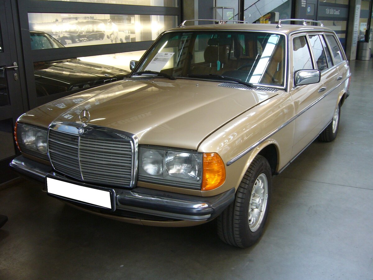 Mercedes Benz W123 230E T-Modell. Dieses 230E T-Modell der Baureihe W123 bzw. S123 wurde erstmalig im August 1981 zugelassen. Das Kombimodell gehört somit zur dritten und letzten Serie (MoPf) dieser Baureihe, wie sie von September 1982 bis zum Produktionsende im Januar 1986 im Werk Bremen montiert wurden. Der Vierzylinderreihenmotor hat einen Hubraum von 2276 cm³ und leistet 136 PS. Interessant ist vielleicht noch zu erwähnen, dass dieser Benz mit der damals aufpreispflichtigen dritten Sitzbankreihe im Kofferraum ausgestattet ist. Auf dieser konnten zwei Personen Platz nehmen und hatten dann freie Sicht durch die Heckscheibe. Classic Remise Düsseldorf am 12.07.2023.