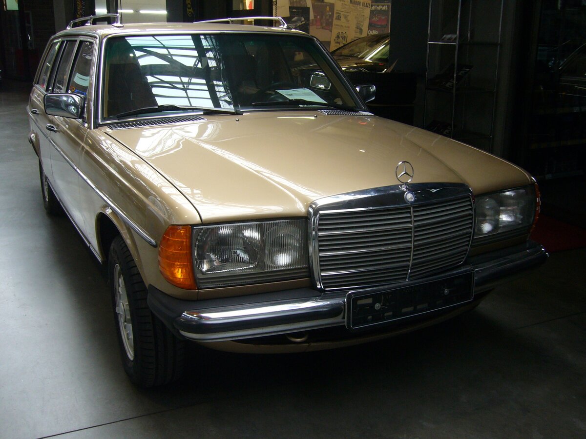 Mercedes Benz W123 230E T-Modell im Farbton champagnermetallic. Dieses 230E T-Modell der Baureihe W123 bzw. S123 wurde erstmalig im August 1981 zugelassen. Das Kombimodell gehört somit zur dritten und letzten Serie (MoPf) dieser Baureihe, wie sie von September 1982 bis zum Produktionsende im Januar 1986 im Werk Bremen montiert wurden. Der Vierzylinderreihenmotor hat einen Hubraum von 2276 cm³ und leistet 136 PS. Interessant ist vielleicht noch zu erwähnen, dass dieser Benz mit der damals aufpreispflichtigen dritten Sitzbankreihe im Kofferraum ausgestattet ist. Auf dieser konnten zwei Personen entgegen der Fahrtrichtung Platz nehmen und hatten dann freie Sicht nach hinten. Classic Remise Düsseldorf am 30.10.2023.