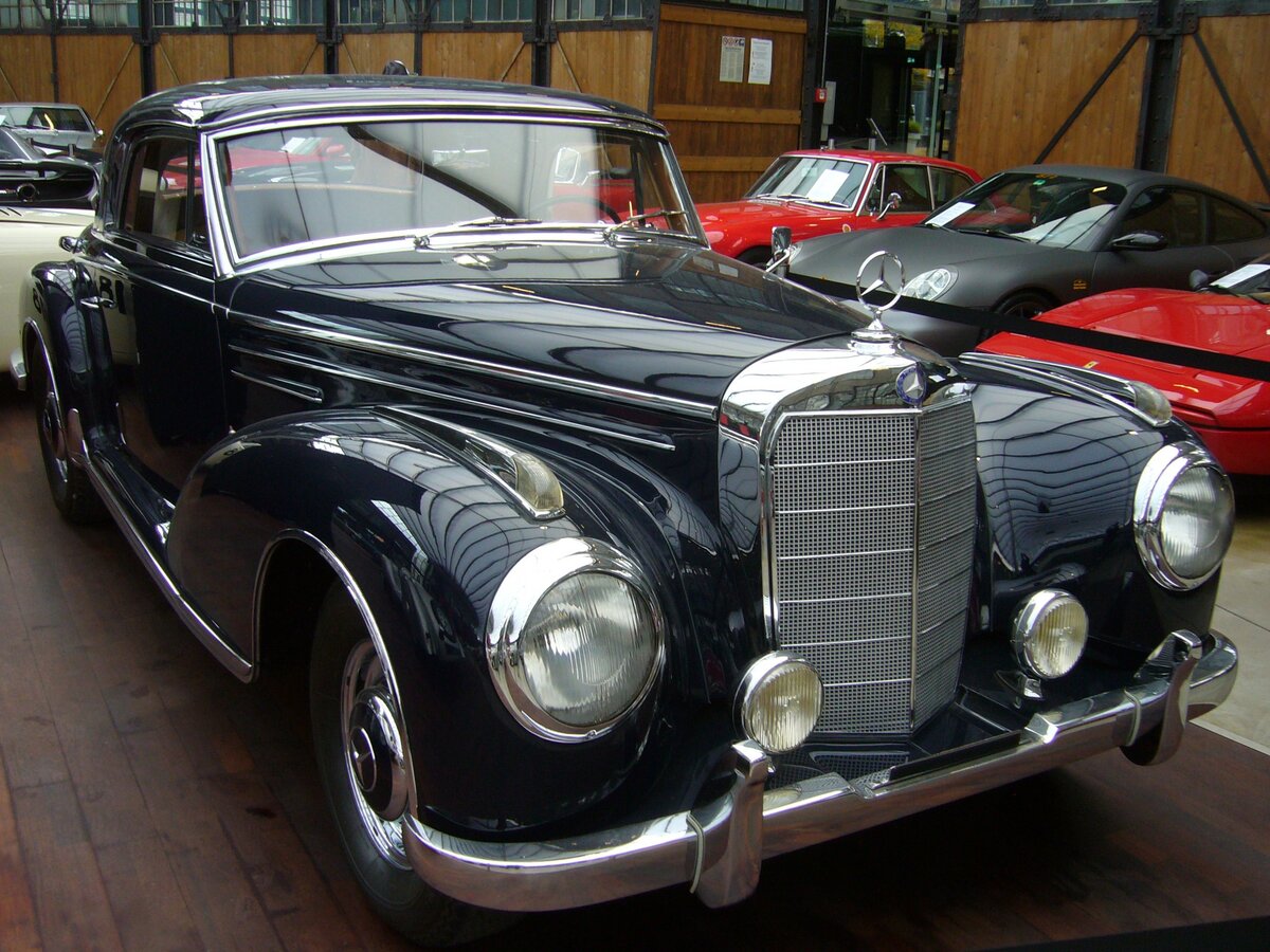 Mercedes Benz W188 II 300Sc aus dem Jahr 1956. Mit der Baureihe W188 300S bezeichnete Mercedes Benz die Cabriolet- und Coupe Modelle der Baureihen W186 und W189, besser bekannt als  Adenauer-Benz . Die Baureihe W188 kam im Sommer 1952 auf den Markt. Anfang 1956 stand dann die modernisierte Baureihe W188 II 300Sc im Verkaufsprospekt der Untertürkheimer. Der Sechszylinderreihenmotor mit einem Hubraum von 2996 cm³ hatte durch eine Benzineinspritzung von Bosch nun 175 PS. Die Höchstgeschwindigkeit gaben die Schwaben mit 180 km/h an. Insgesamt verkaufte Mercedes Benz von diesem 300Sc Coupe-Modell während der gesamten Laufzeit nur 98 Fahrzeuge. Der Preis für ein solches Fahrzeug betrug mindestens DM 36.500,00. Wir erinnern uns, acht Jahre vorher, hatte jeder Bundesbürger nach der Währungsreform, mit DM 40,00 angefangen! Classic Remise Düsseldorf am 15.10.2022.