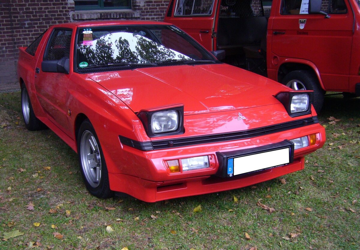Mitsubishi Starion, produziert von 1982 bis 1990. Der Starion kam als Konkurrenz zu den potenten Sportcoupes   a´la Nissan ZX und Mazda RX7 auf den Markt. Vorgestellt wurde das Modell auf dem Genfer Salon des Jahres 1982. Der Vierzylinderreihenmotor mit Turboaufladung stammt vom Mitsubishi Lancer 2000 und hat einen Hubraum von 1997 cm³. Anfangs leistete dieser Motor 170 PS. Ab Mai 1985 erhöhte sich die Leistung auf 180 PS. Bei den Fahrzeugen die ab September 1987 verkauft wurden, wurde der Hubraum auf 2555 cm³ aufgebohrt. Jetzt leistete der Motor 155 PS, allerdings mit geregeltem Katalysator. Oldtimertreffen beim Theater an der Niebu(h)rg am 22.10.2023 in Oberhausen.
