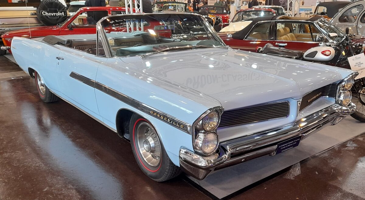 Pontiac Bonneville Convertible aus dem Jahr 1963 im Farbton kimberly blue. Im Modelljahr 1963 war der Bonneville das Spitzenmodell im Programm der GM-Division Pontiac. Darunter rangierte der Star Chief. Basismodell war die Catalina-Baureihe. Von diesem Cabriolet wurden im Jahr 1963 22.016 Fahrzeuge produziert. Der Wagen war in den Bundesstaaten der Ostküste ab US$ 3578,00 zu haben. In den Bundesstaaten des mittleren Westens und der Westküste lag der Preis schon bei US$ 3995,00. Spitzenmotorisierung war ein V8-Motor mit einem Hubraum von 6364 cm³ und einer Leistung von 370 PS. Techno Classica Essen am 27.03.2022.
