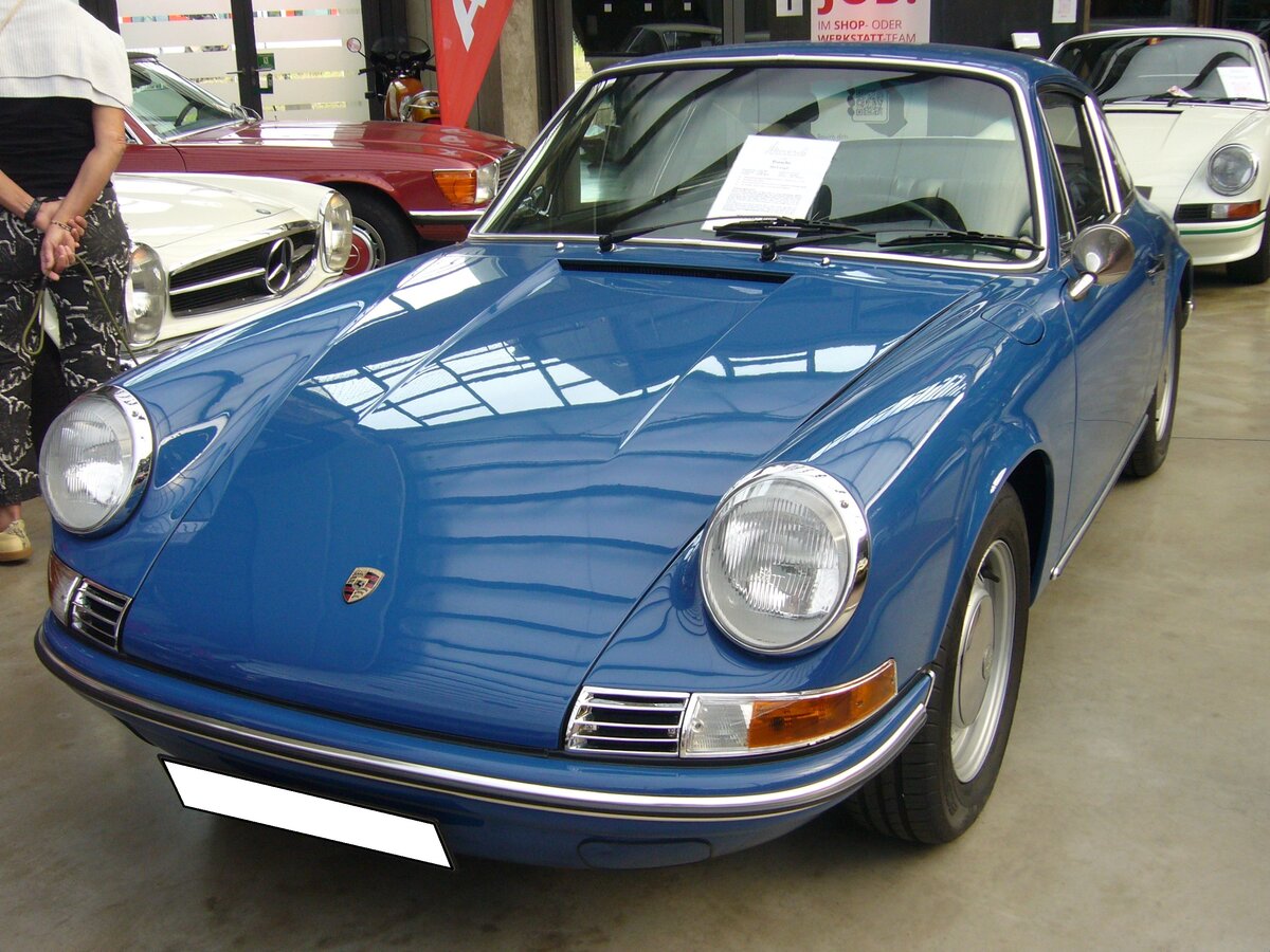 Porsche 912, gebaut in den Jahren von 1965 bis 1969. Dieser Wagen aus dem letzten Modelljahr 1969 ist im Farbton aga blau lackiert. Porsche stellte 1965 die Produktion des Modells 356 ein. Um auch weniger finanzkräftigen Kunden weiterhin einen Porsche anbieten zu können, wurde der Vierzylinderboxermotor des 356C in die Karosserie des 911´er verpflanzt. Der Motor leistet 90 PS aus einem Hubraum von 1582 cm³. Bei seiner Markteinführung schlug ein solcher Porsche 912 mit einem Kaufpreis von mindestens DM 16.250,00 zu Buche, während man für das Modell 911 schon mindestens DM 21.900,00 anlegen musste. Classic Remise Düsseldorf am 20.09.2023.