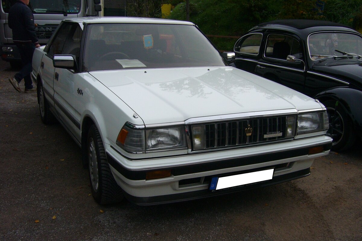 Toyota Crown Royal Saloon der Serie GS121 aus dem Jahr 1986. Das Luxusmodell Crown der Series 120 wurde von 1983 bis 1987 produziert. Der gezeigte Crown Royal Saloon wurde 1986 in Japan erstmalig zugelassen und später nach Deutschland importiert. Serienmäßig ist dieses Fahrzeug mit einer Klimaautomatik, einem Lichtsensor, einem Viergangautomaticgetriebe mit Overdrive, einer Zentralverriegelung, elektrischen Fensterhebern, einer verschiebbaren Rücksitzbank und einem Digitaltachometer ausgestattet. Der abgelichtete  Crown  ist mit dem schwächsten, damals lieferbaren, Motor ausgerüstet. Der Sechszylinderreihenmotor hat einen Hubraum von 1988 cm³ und leistet 160 PS. Die Höchstgeschwindigkeit wurde mit 190 km/h angegeben. Oldtimertreffen am Theater an der Niebu(h)rg in Oberhausen am 23.10.2022.