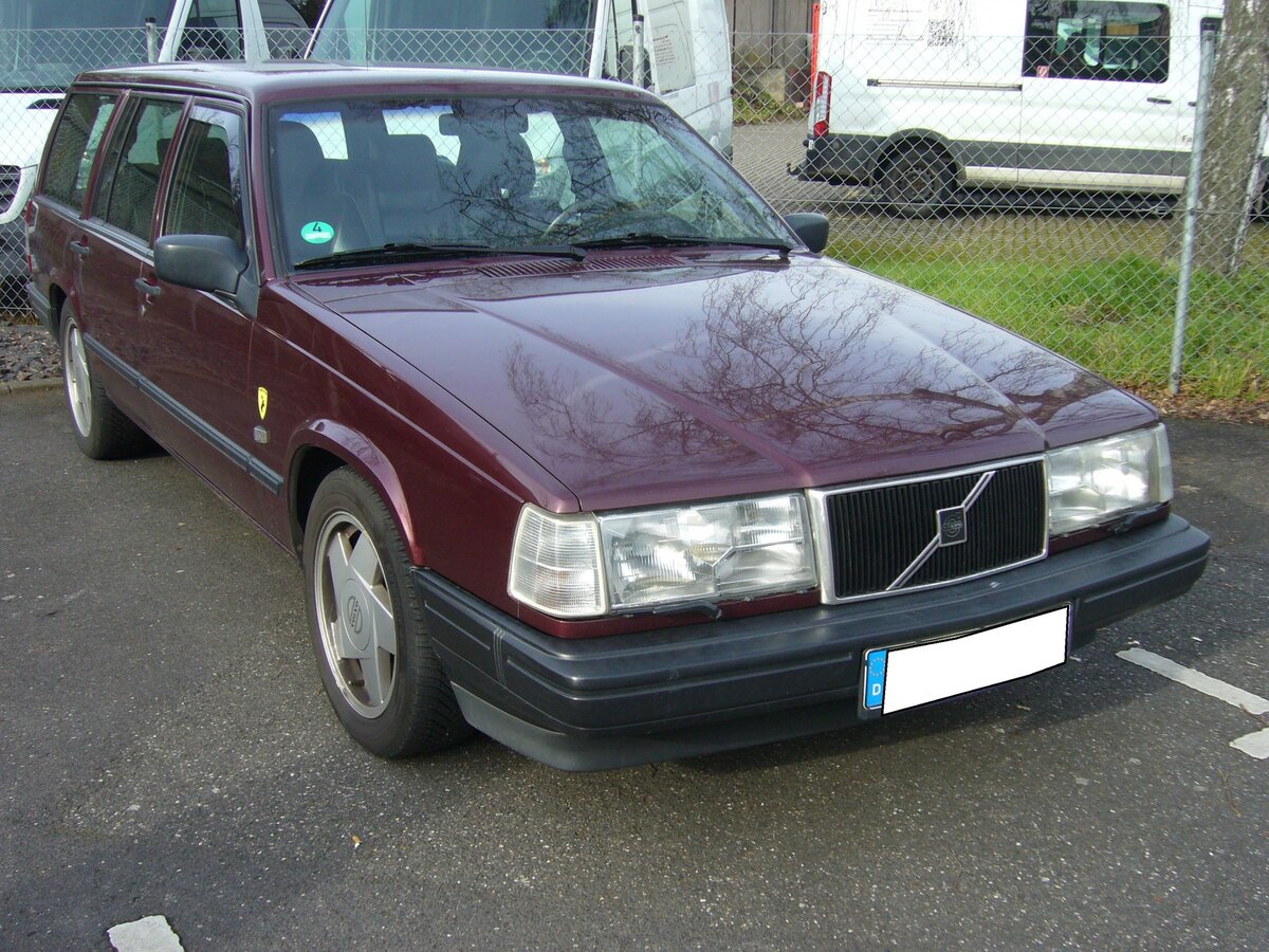 Volvo 940 Kombi. Die so genannte Volvo 900´er Serie kam 1990 auf den Markt und wurde bis 1998 mit einigen optischen und technischen Retuschen produziert. Die Baureihe war als viertürige Limousine oder fünftüriges Kombimodell lieferbar. Die 940´er Modelle waren mit einem Vierzylinderreihenmotor ausgerüstet, während die 960´er Modelle Sechszylinderreihenmotoren haben. Hier konnte ich ein Modell der Baujahre von 1994 bis 1996 ablichten. Es waren 2.0l und 2.3l Benzinmotoren mit einem Leistungsspektrum von 112 PS bis 165 PS lieferbar. Besucherparkplatz der Düsseldorfer Classic Remise am 22.02.2023.