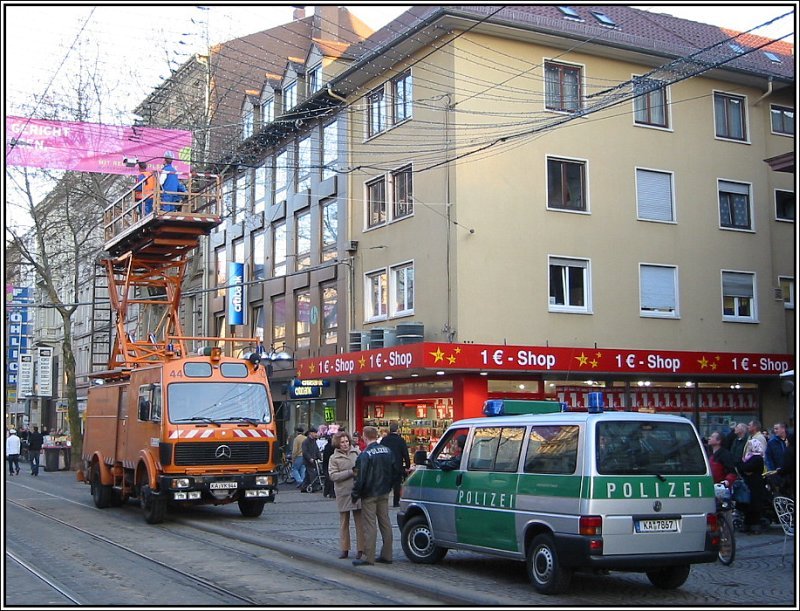 Am 15.03.2005 gab es Probleme mit der Oberleitung fr die Straen- und Stadtbahnen in der Karlsruher Innenstadt. Whrend ein Oberleitungstrupp der Verkehrsbetriebe mit der Reparatur beschftigt war und dabei dieses Fahrzeug mit Hebebhne einsetzte, sperrte die Polizei die unmittelbare Umgebung ab und war unter anderem mit diesem VW-Kleinbus vor Ort. 