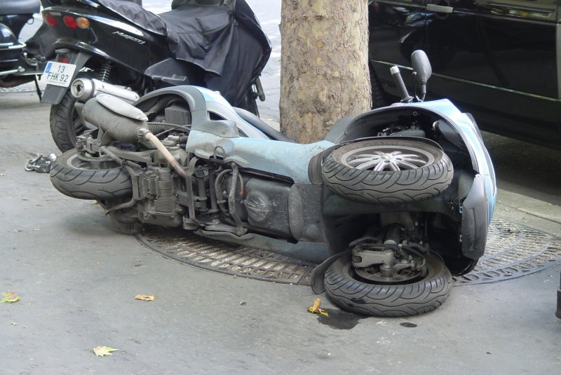 Auch eine Mglichkeit sein Motorrad vor Diebstahl zu sichern. Umgelegt und an den Baum angekettet. Hier eine Piaggio MP3 400 ie, gesehen in Paris am 14.07.2009