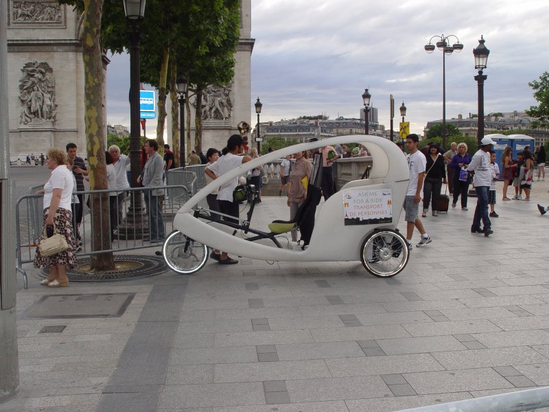Auch in Paris gibt es jetzt Fahrradrikschas. Hier ein stromfrmiges Exemplar am 13.07.2009 an der Place de l'Etoile (Charles de Gaulle) am Triumphbogen.