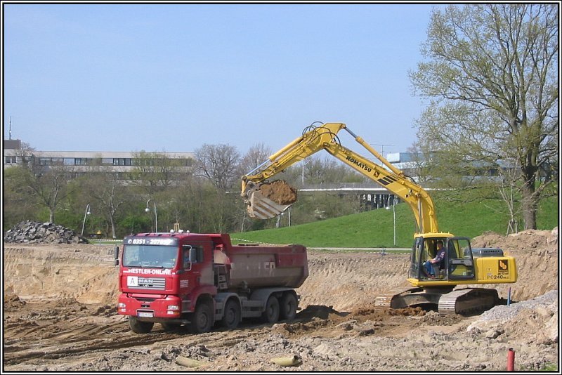 Ein Bagger (Hersteller Komatsu) beldt am 19.04.2006 einen MAN-Kipper auf einer Baustelle in der Nhe der Europahalle in Karlsruhe. Hier wurde eine Baugrube ausgehoben fr ein neues Freizeitbad.