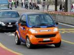 Orange-Blauer Smart mit Werbung unterwegs in Luzern am 10.04.2010