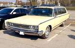 Chrysler Town & Country Wagon des Modelljahres 1966 im Farbton daffodil yellow. Ein solcher Town & Country war im Jahr 1966 ab US$ 4086,00 zu haben. Der V8-Motor hat einen Hubraum von 383 cui (6276 cm³) und leistet, je nach Vergaserbestückung, 290 PS oder 330 PS. Besucherparkplatz der Techno Classica Essen am 26.03.2022.