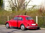 VW Kfer-1300 lsst die morgendlichen Sonnenstrahlen auf seine rote Farbe einwirken; 120409