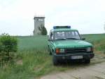 Land Rover steht neben dem ehem. Kolonnenweg zwischen Bayern und Thüringen. Im Hintergrund ein alter Beobachtungsturm. 