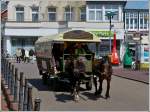 Voll mit Fahrgsten ist diese Pferdegespann mit Planwagen auf der Insel Borkum unterwegs.