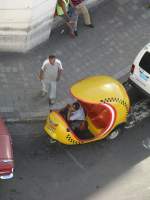 Coco-Taxi. Die gnstige kubanische Art Taxi zu fahren. Zwei Personen und der Fahrer knnen in den dem an eine Kokosnuss erinnernden (daher der Name) Gefhrt auf Vespa-Basis mitfahren.
 
Santiago de Cuba
09-2003
