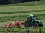 Deutz Traktor mit Heuwender, aufgenommen beim Aufschwaden des abgemhten Feldes.