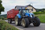 Traktor New Holland T7030,  mit Hänger auf dem Heimweg.