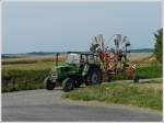Deutz Traktor mit Heuwender unterwegs zum nchsten Feld.