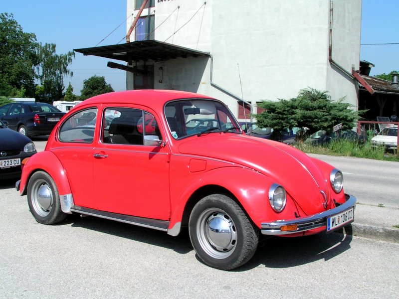 VW-Kfer in schn leuchtender roter Farbe steht am Parkplatz des Bhf. Marchtrenk;090525
