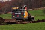 VOLVO ECR 145 EL; der Raupenbagger ist dabei vorsichtig die obere Erdschicht ber dem felsigen Boden abzutragen.