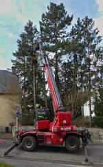 Magni Teleskoplader, mit Aufsatz zum Baumf�llen, beim f�llen von B�umen mitten in einem Dorf. 03.2026